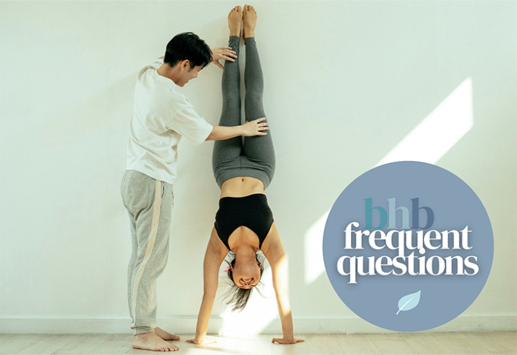 Woman doing handstand against a wall.