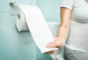Person pulling on roll of toilet paper.
