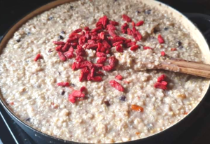 Large pot of superfood porridge with goji berries on the top.