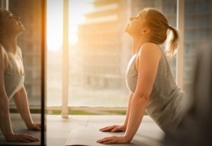 Woman doing a yoga pose in front of a window.