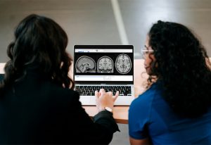 People examining brain scans on a computer.