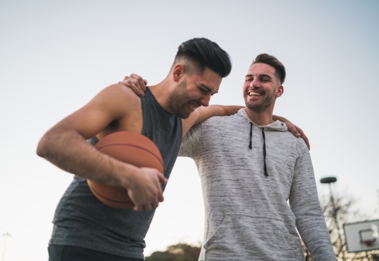 Two men embracing while playing basketball.