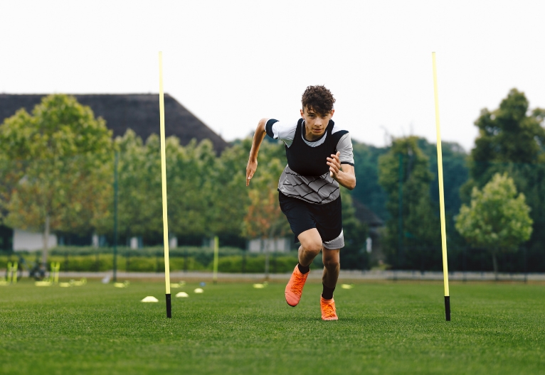 Teenage boy training on a field.