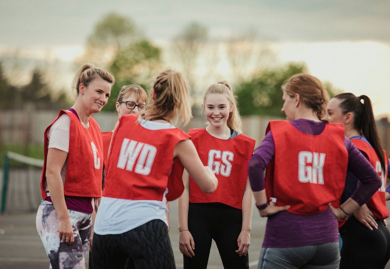 Teenage girls playing netball.