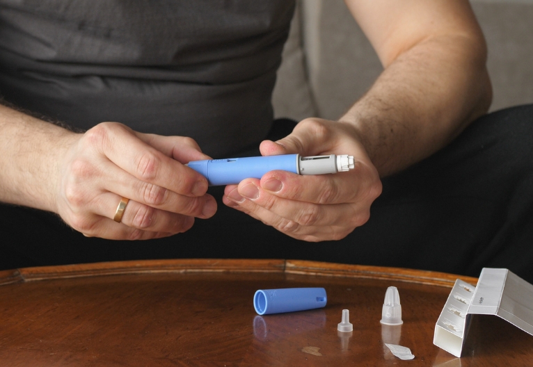Man holding Ozempic injector. 