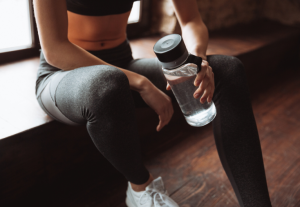 Woman sitting down with water after exercising