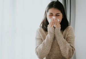 Woman blowing her nose.