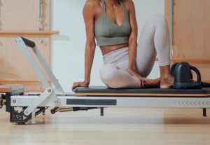 Instructor sitting on pilates reformer