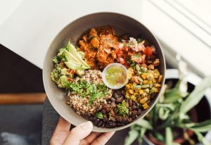 Person holding a bowl of healthy food.
