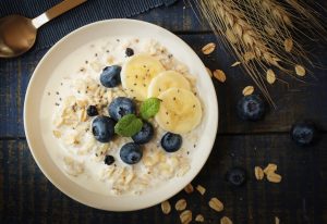 A bowl of porridge topped with blueberries and sliced banana.