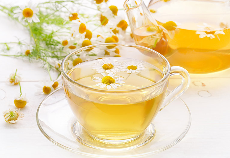 Clear mug of chamomile tea.