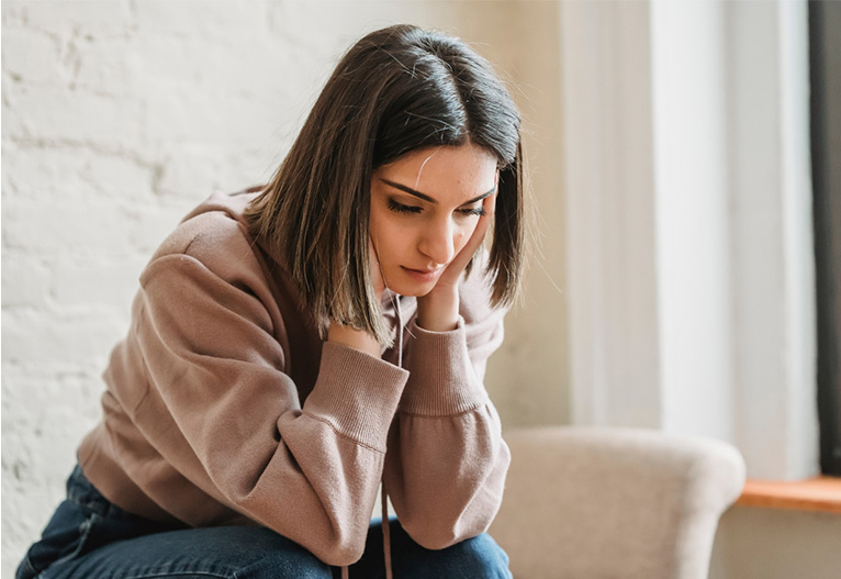 Worried woman sitting on a sofa.