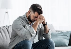 Worried man sitting on a sofa.