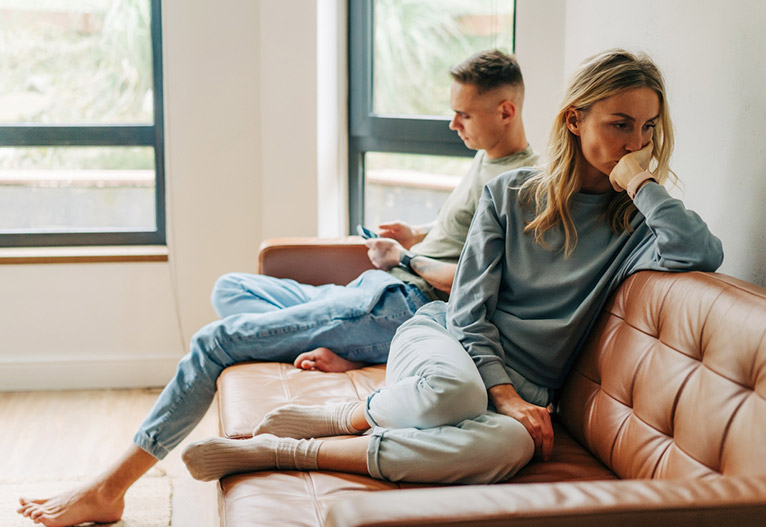 Unhappy couple on a sofa.