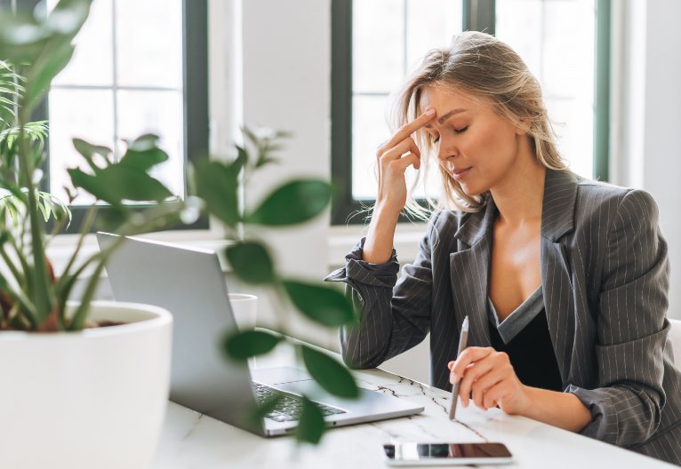 Unhappy woman at her desk at work.