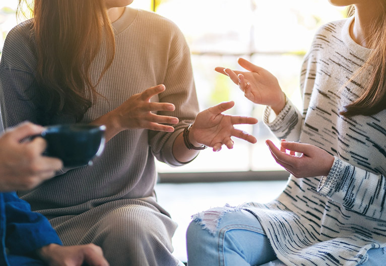 Women talking using their hands.