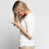 Woman slouching over her phone.