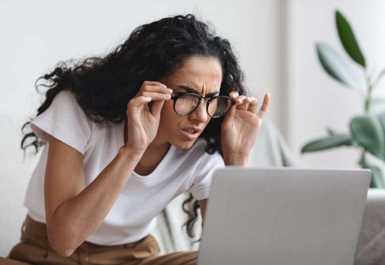 Woman straining to see her computer screen.