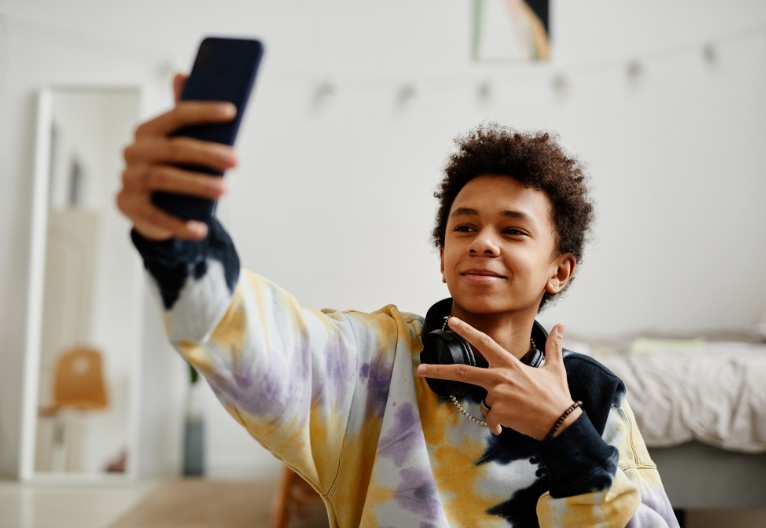 Boy taking a selfie with his smartphone.