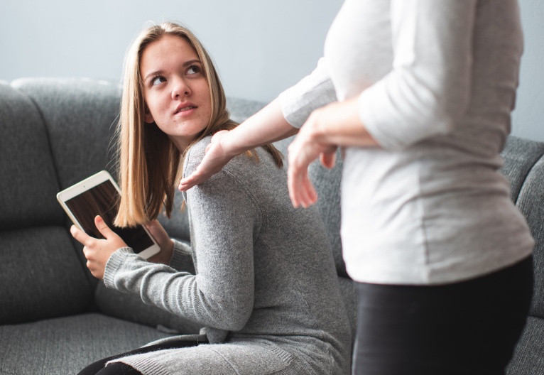 Mother tries to take an iPad off her teenage daughter.