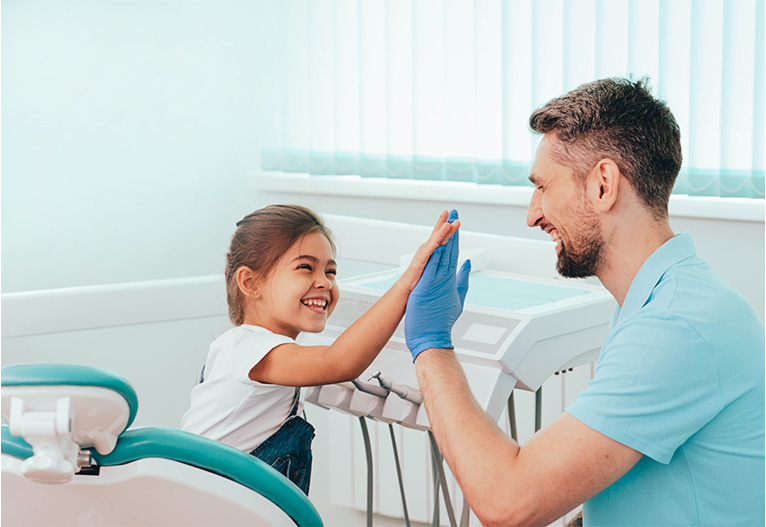 Child high-fiving her dentist.