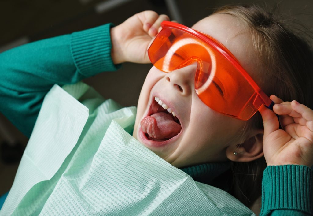 Child wearing bright glasses at the dentist.