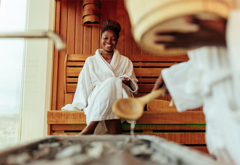 Smiling woman sitting in a sauna.