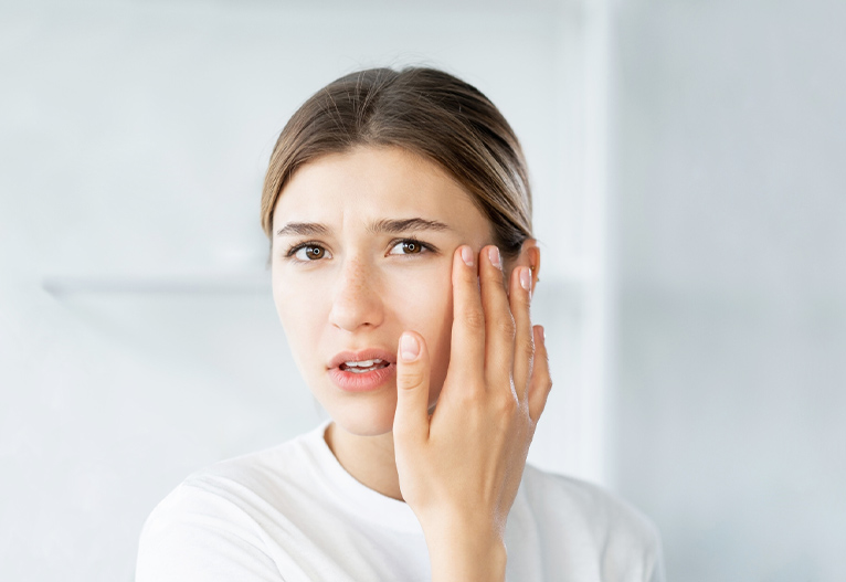 Worried woman touching her face.