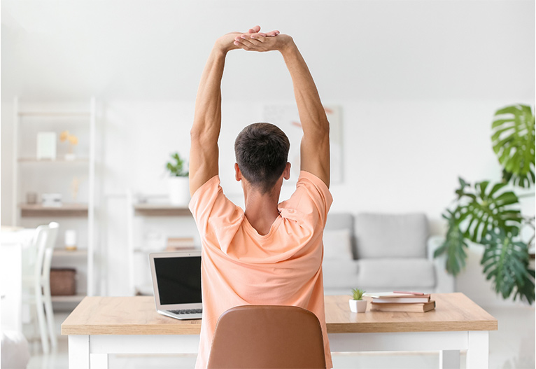 Man stretching at his desk.