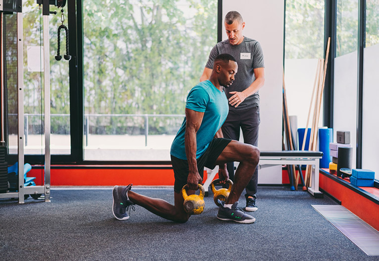 Man training with a weights at a gym.