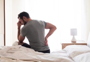 Man on bed with sore back.