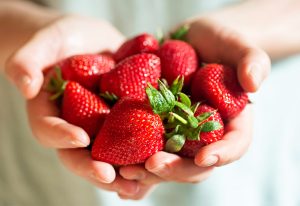 Person holding strawberries.