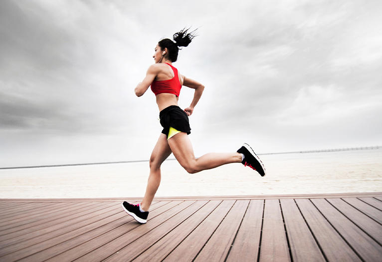 Fit woman running on a pier.