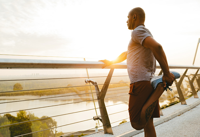 Fit man stretching after a jog.