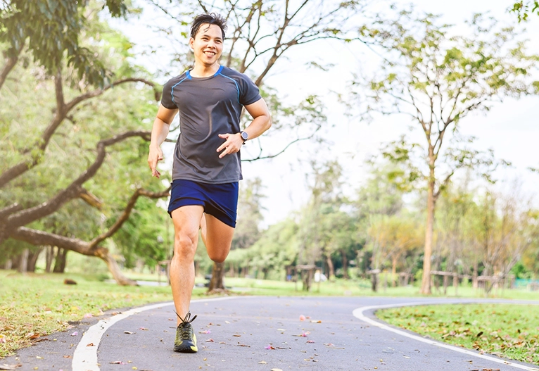 Happy man jogging on a path.