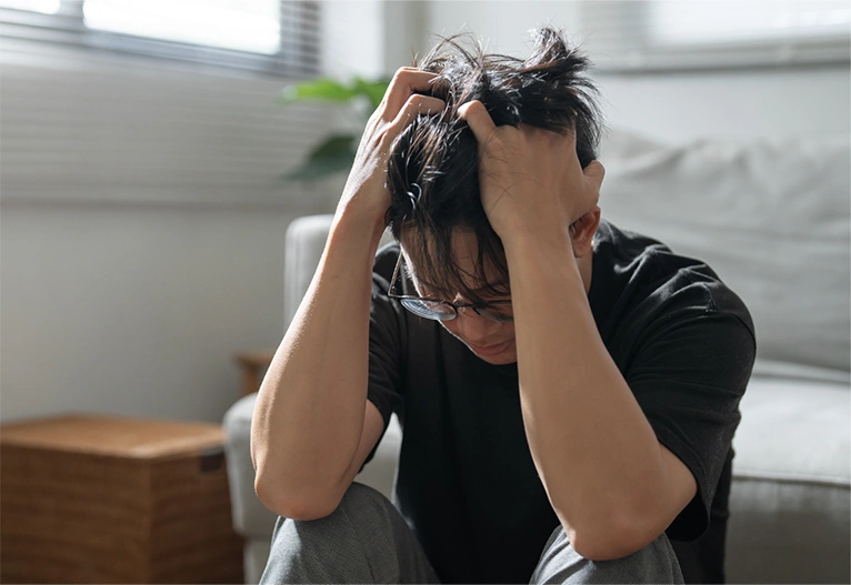 Anxious man with his head on his hands.