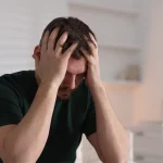 Man with his head in his hands.