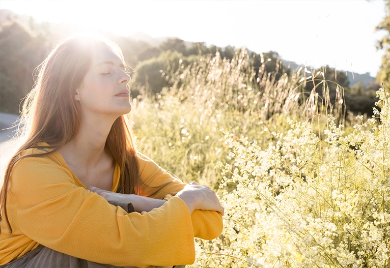 Woman sitting in a field relaxing.