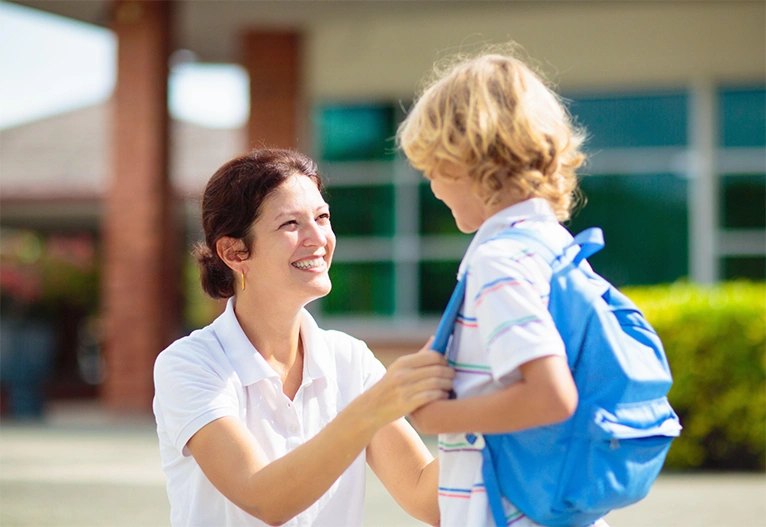 Child talking to a teacher.